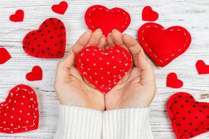 Heart in Hand on wooden table. girl give heart on valentine day photo