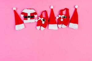 Top view of colorful holiday background made of Santa hats and clothes. Merry Christmas concept with copy space photo