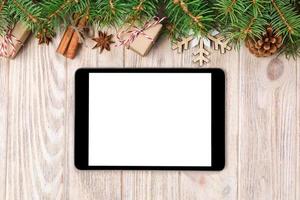 Digital tablet mock up with rustic Christmas wood background decorations for app presentation. top view with copy space photo