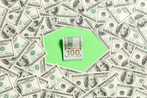 marco de billetes de cien dólares con pila de dinero en el medio. vista superior del concepto de negocio sobre fondo verde con espacio de copia foto