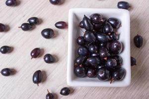 black currant in glassware on white wooden table top view photo
