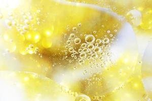 Gold Oil bubbles close up. circles of water macro. abstract shiny yellow background photo