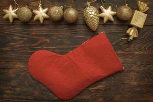Gold balls and toys with Christmas sock on a wooden background photo