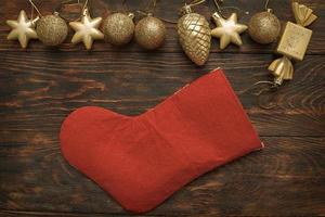 Gold balls and toys with Christmas sock on a wooden background photo