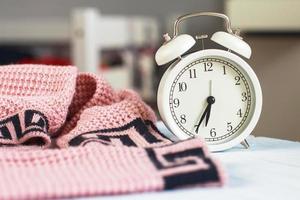 Cozy winter morning . knitted sweater and alarm clock in the bedroom photo