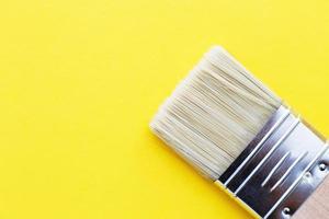 Paint brush isolated on a yellow background close with copy space photo