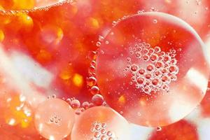 las burbujas de aceite se cierran. círculos de agua macro. fondo naranja abstracto y rojo fuego foto