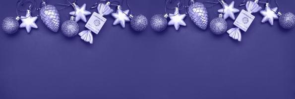 Christmas balls and toys on a blue background. Very Peri color of the year. photo