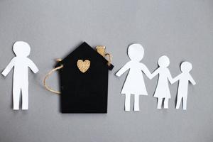 Paper chain cut family near toy house on gray background. Divorce and broken family concept photo