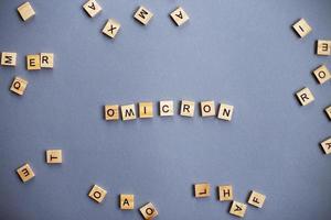 word omicron made by wooden blocks on gray background. photo