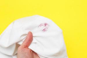 Woman holding a white shirt with red kiss lipstick on a yellow background photo