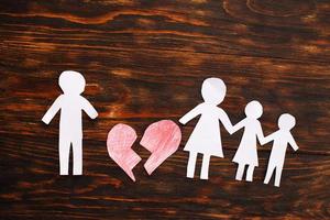 Paper chain cut family with broken heart on wooden background. Divorce and broken family concept photo