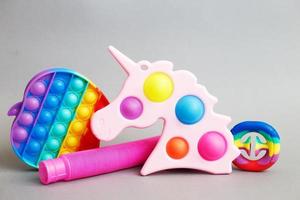 coloridos juguetes sensoriales antiestrés sobre un fondo gris. foto