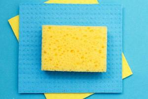 kitchen rags and sponges on a blue background. flat lay photo