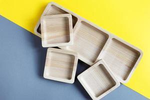 wood empty plates for snack on color grey and yellow background photo