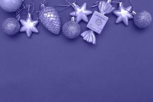 Gold Christmas balls and toys on a blue background. Very Peri color of the year. photo