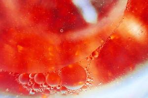 Oil bubbles close up. circles of water macro. abstract orange and fiery red background photo