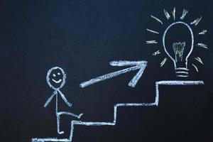 drawn man on the chalk board climbs up step by step to the top of career stairs. copy space photo