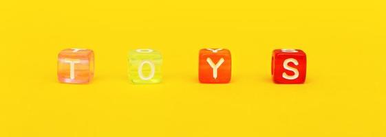 Word toys with colorful cubes of beads on yellow. banner photo