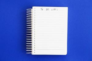 Top view of blank note paper on blue background. to do list photo