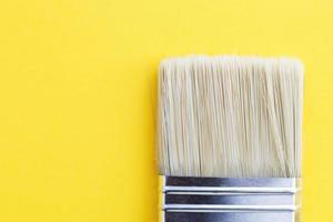 Paint brush isolated on a yellow background close with copy space photo