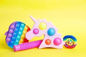 colorful antistress sensory fidget toys on a yellow background. photo