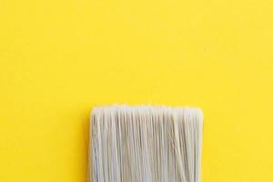 Paint brush isolated on a yellow background close with copy space photo