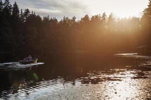 dad and son are sailing on a boat on the lake for fishing photo