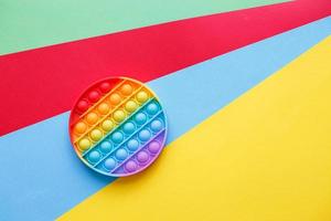 pop moderno de juguete de silicona sobre un fondo multicolor. juguete antiestrés educativo para niños foto