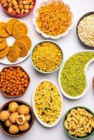 Indian Tea time snacks in group. Sev, chivda, farsan, mixture, bakarwadi served in different bowls photo