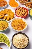 Indian Tea time snacks in group. Sev, chivda, farsan, mixture, bakarwadi served in different bowls photo