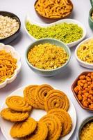 Indian Tea time snacks in group. Sev, chivda, farsan, mixture, bakarwadi served in different bowls photo