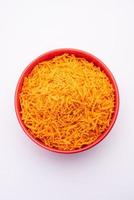 Tomato sev is a crispy crunchy orange colored flavored fried farsan with salt and spice powders photo
