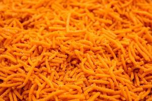 Tomato sev is a crispy crunchy orange colored flavored fried farsan with salt and spice powders photo