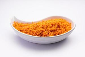 Tomato sev is a crispy crunchy orange colored flavored fried farsan with salt and spice powders photo