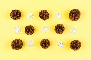 Top view of New Year ornament made of white snowflakes and pine cones on colorful background. Winter holiday concept with empty space for your design photo