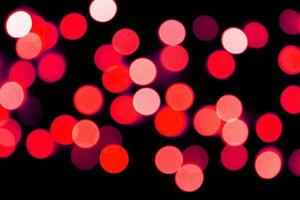Unfocused abstract red bokeh on black background. defocused and blurred many round light photo
