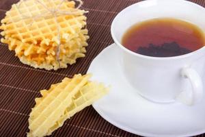 Breakfast with Waffles, Pieces of Waffle and Black Cup of Tea on Wooden Surface photo