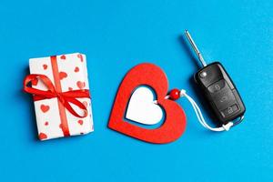Top view of car key, gift boxes and toy heart on colorful background. Close up of Saint Valentine's Day concept photo