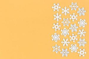 vista superior del adorno de invierno hecho de copos de nieve blancos sobre fondo colorido. concepto de feliz año nuevo con espacio de copia foto
