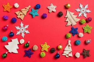 Top view of holiday decorations and toys on red background. Christmas ornament concept with empty space for your design photo