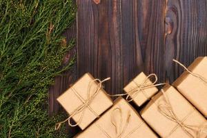 Christmas fir tree branches with gift box on dark rustic wooden background with copy space for text photo