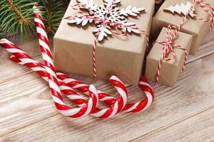 Christmas gift boxes and fir tree branch on wooden table. Top view with copy space photo
