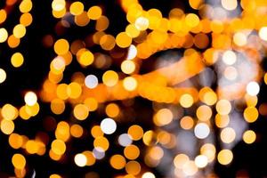 Unfocused abstract gold bokeh on black background. defocused and blurred many round light photo