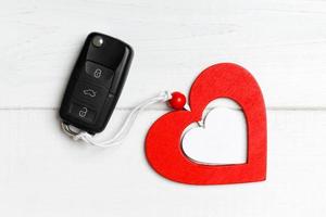 Top view of car key and heart as a present for Valentine's day on wooden background. Romance concept photo