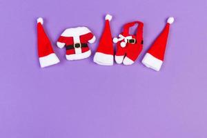 Top view of colorful holiday background made of Santa hats and clothes. Merry Christmas concept with copy space photo