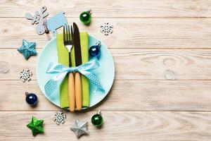 Holiday composition of Christmas dinner on wooden background. Top view of plate, utensil and festive decorations. New Year Advent concept with copy space photo