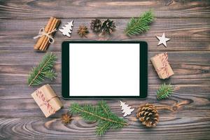 Digital tablet mock up with rustic Christmas wooden vintage background decorations for app presentation. top view with copy space photo