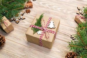 Christmas background with fir tree and gift box on wooden table. Top view with copy space for your design photo