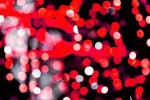 Unfocused abstract red bokeh on black background. defocused and blurred many round light photo